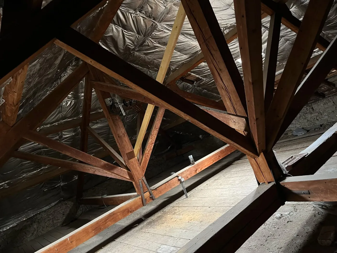 Charpente traditionnelle en bois inspectée par un charpentier